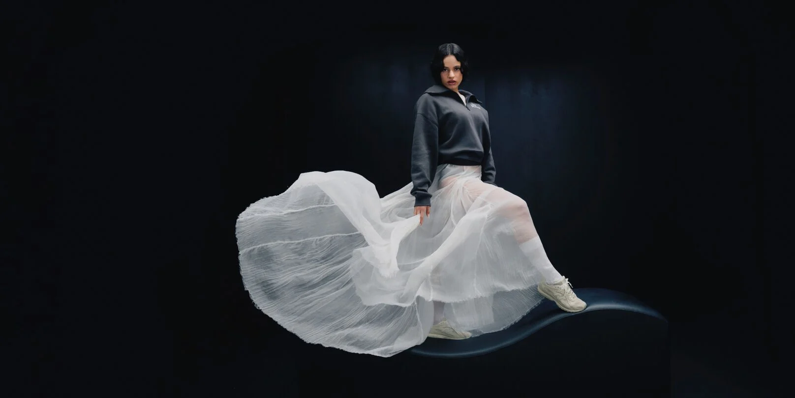 Rosal&iacute;a standing in front of a black studio backdrop. 